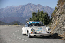 Load image into Gallery viewer, Original Porsche with Cibié Bi-Iodes headlights on mountain road during a rally event.