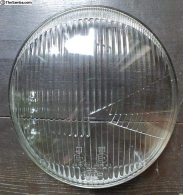 Hella 4475 flat fluted headlight lens with fluted design on wooden background.