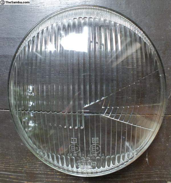 Hella 4475 flat fluted headlight lens with fluted design on wooden background.