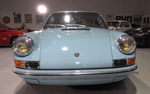 Load image into Gallery viewer, Blue Porsche 911 with Cibié Bi-Iode headlights in a showroom.