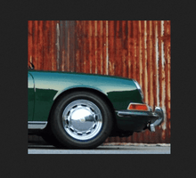 Load image into Gallery viewer, Green classic car with flat fluted lens in front of rusted metal wall.