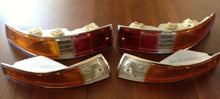 Load image into Gallery viewer, Restored Porsche 911 SWB turn signals and tail lights on wooden surface.