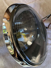 Load image into Gallery viewer, Restored Cibié Bi-Iode 170mm headlight with chrome trim ring on display.