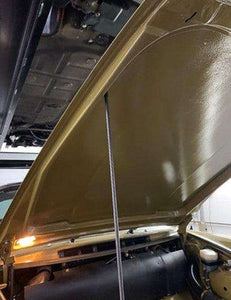 Carbon fiber hood prop installed in car engine compartment.
